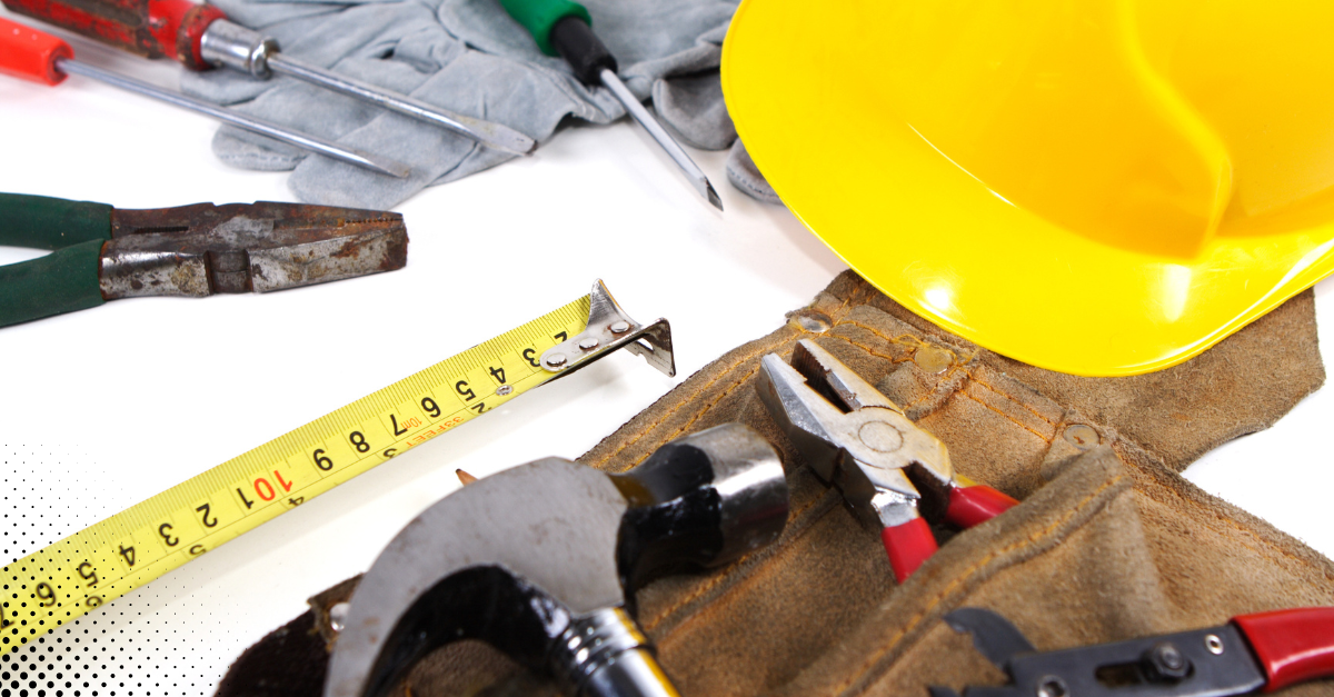 A full tool belt with various hand tools neatly arranged on a blue wooden surface.