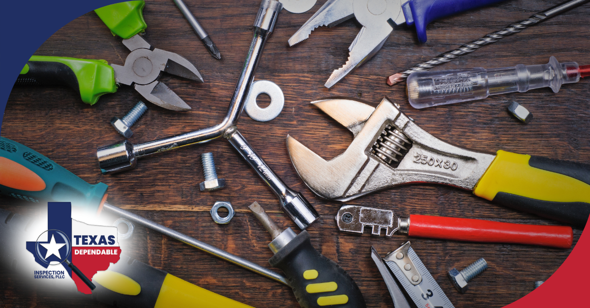 A variety of hand tools and fasteners laid out on a wooden surface.